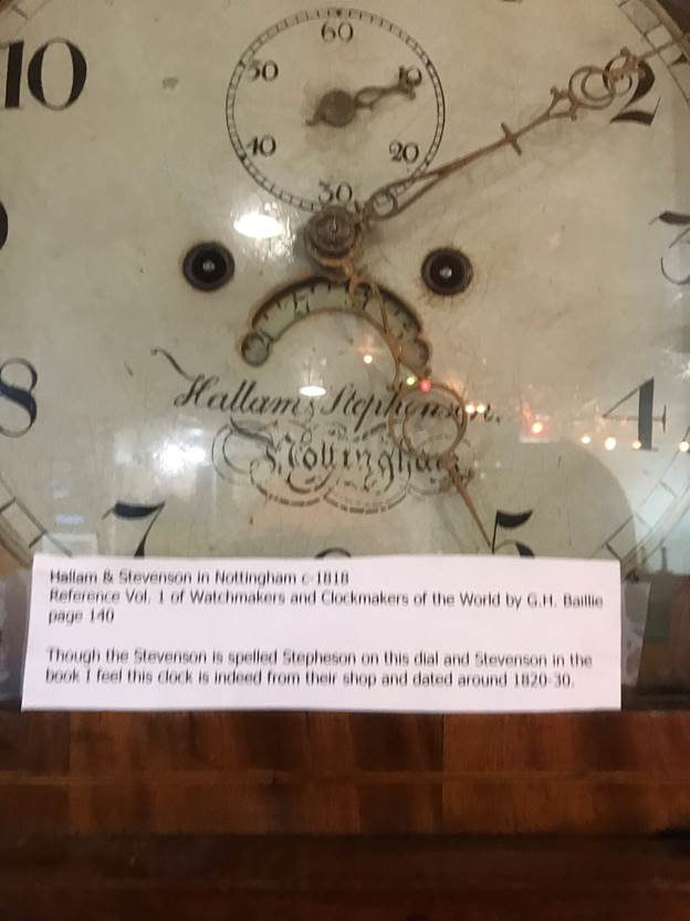 A clock with a sign on it

Description automatically generated